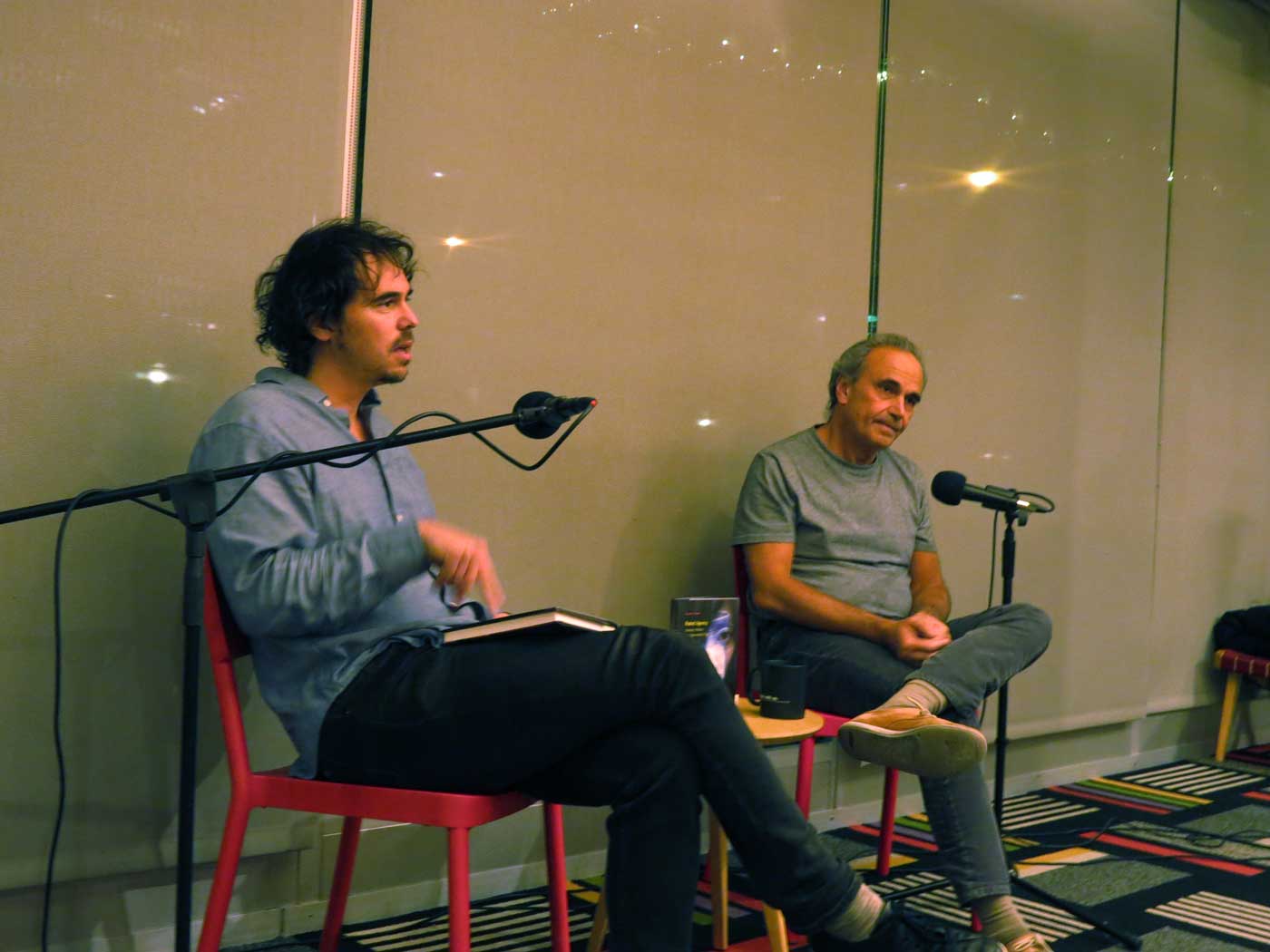 Author Michael Feher and Johnathan Levy sit addressing an audience