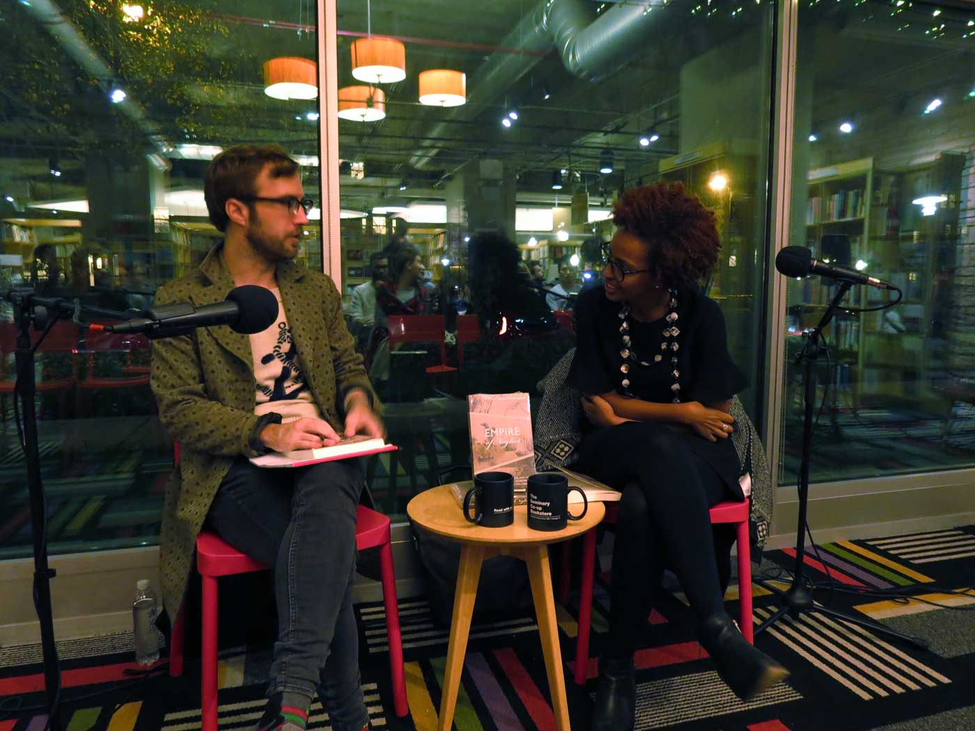 Christopher Taylor sits and speaks to a panelist next to him