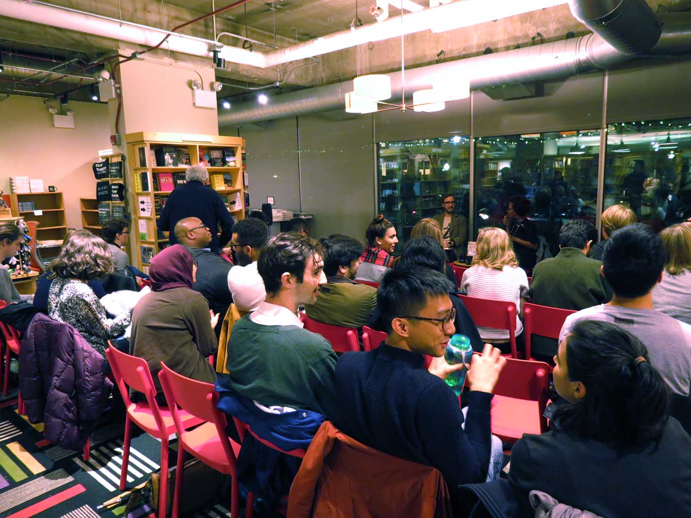 A seated audience listens to Christopher Taylor speak