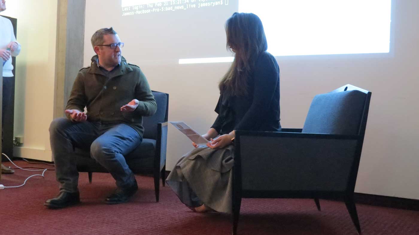 Two people sit in chairs facing each other while talking