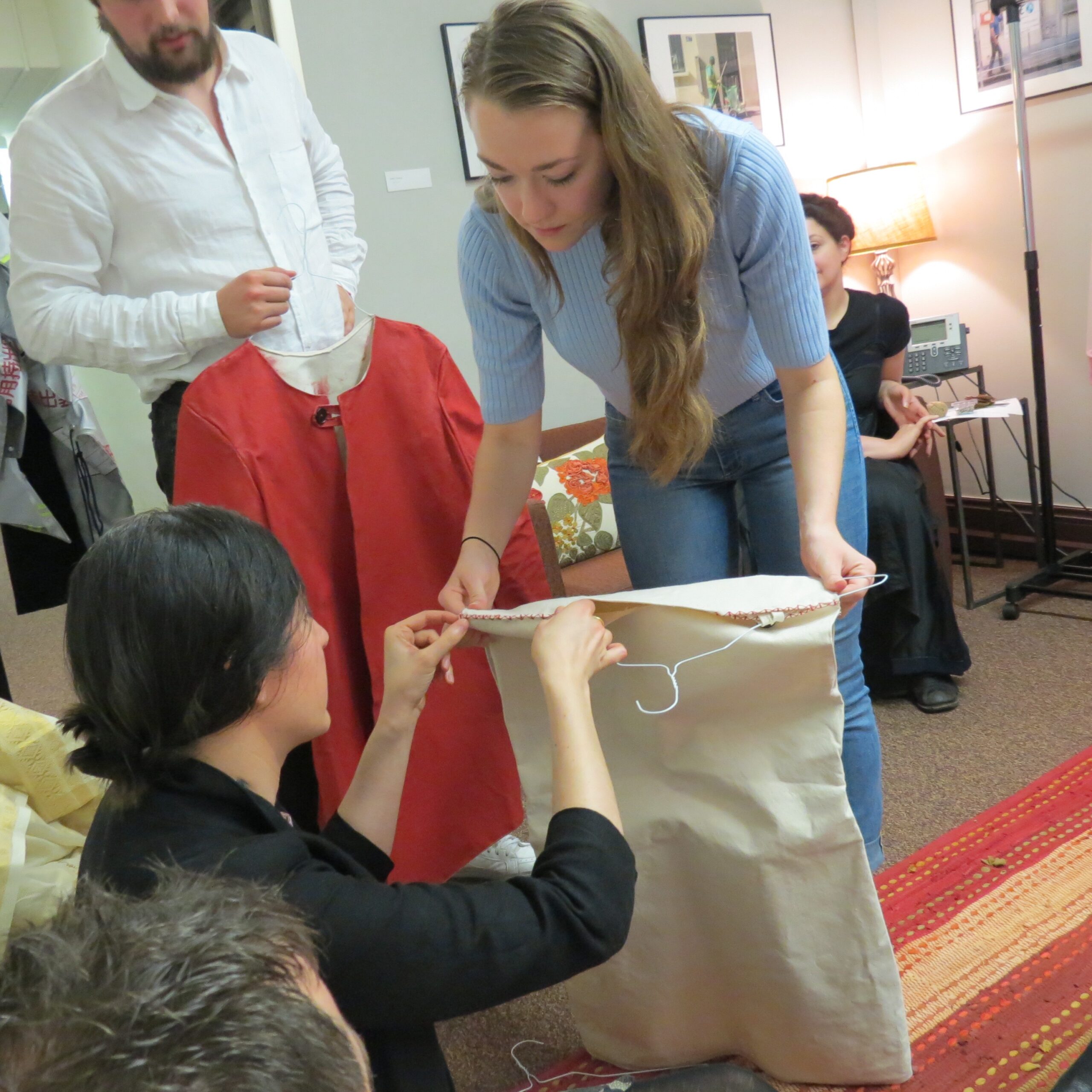 three people working on a garment