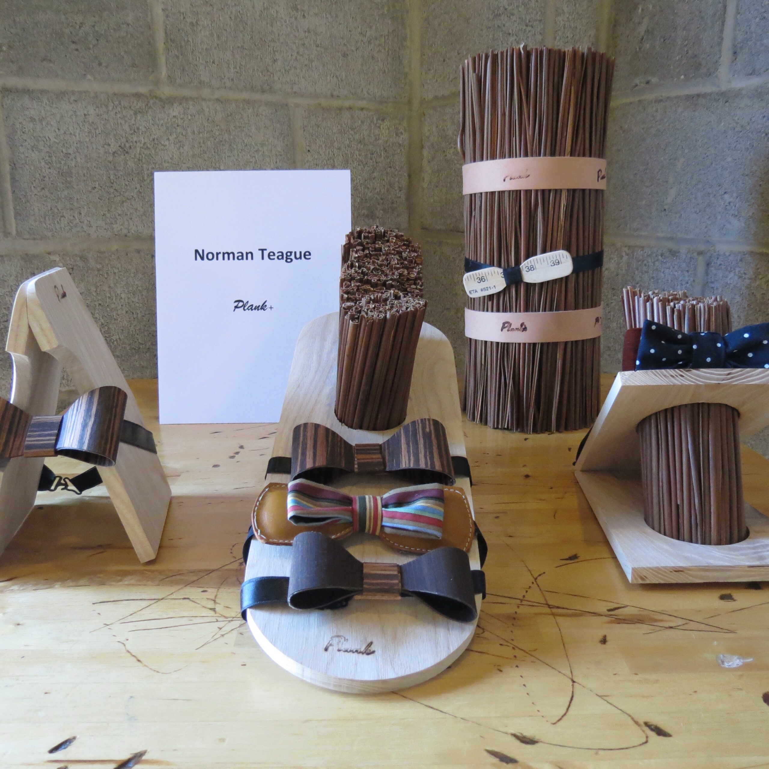 a display of wooden, leather, and fabric bowties by Norman Teague, Plank+