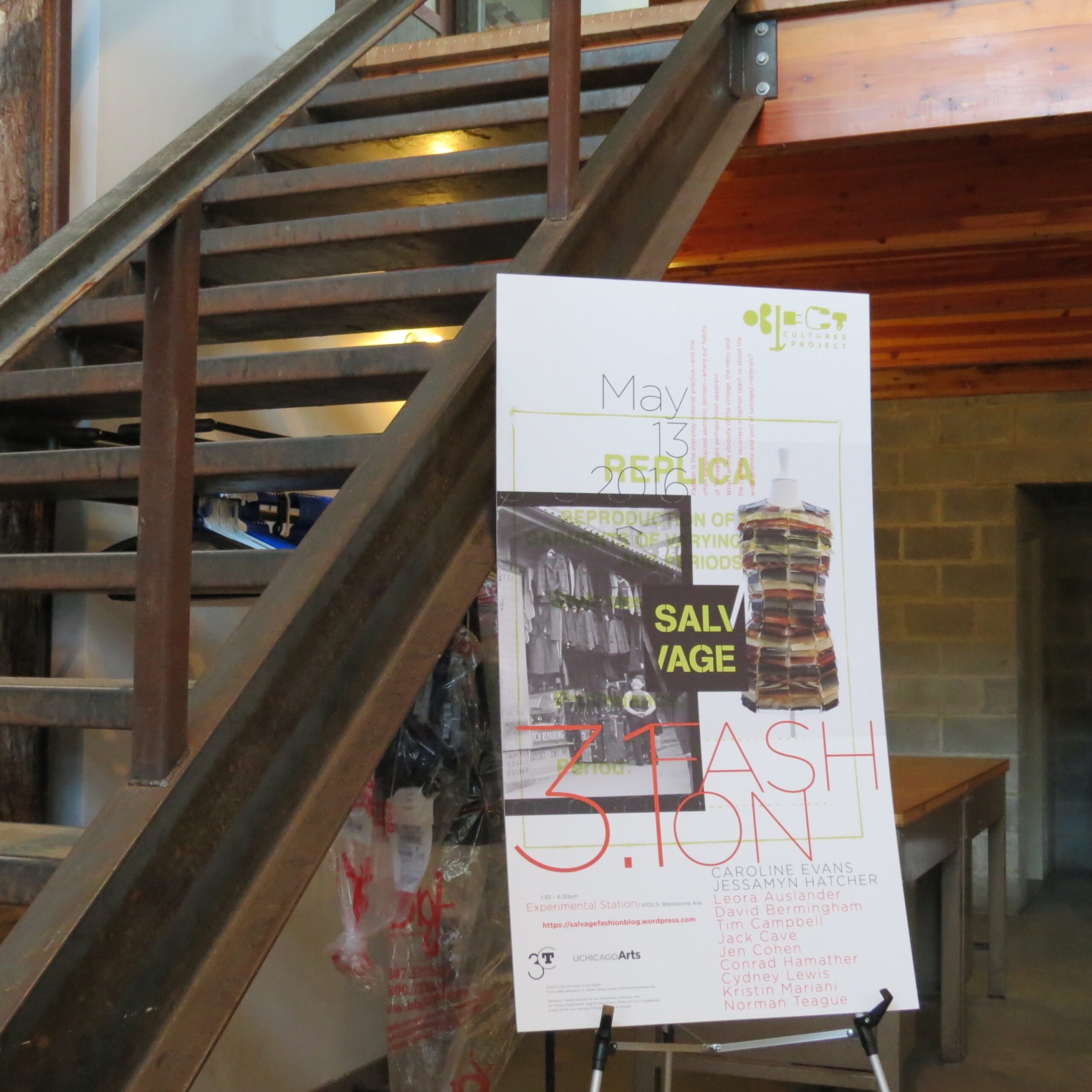 Photo of Salvage 3.1 poster in front of modern wooden staircase