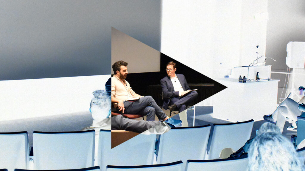 two people sitting in chairs, talking