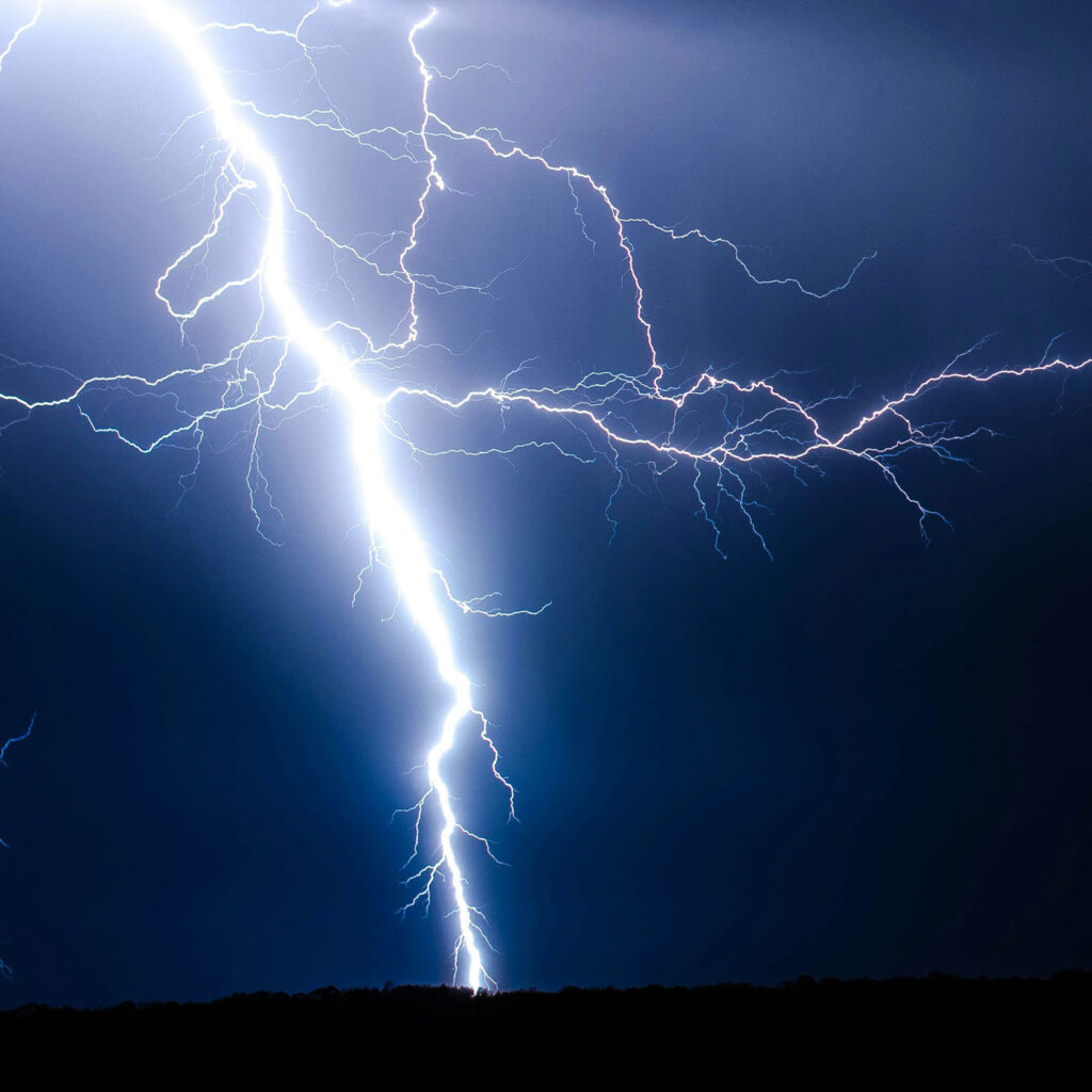 white lightning against blue black sky
